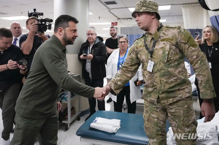 [뉴욕=AP/뉴시스] 제78차 유엔 총회 참석차 미국을 방문한 볼로디미르 젤렌스키(왼쪽) 우크라이나 대통령이 18일(현지시각) 우크라이나 부상 군인들이 입원해 있는 뉴욕의 스태튼 아일랜드 대학병원을 방문해 한 군인과 악수하고 있다. 이 병원에서는 러시아와의 전쟁 중 신체 일부가 절단된 우크라이나 군인들이 치료받고 있다. 2023.09.19.