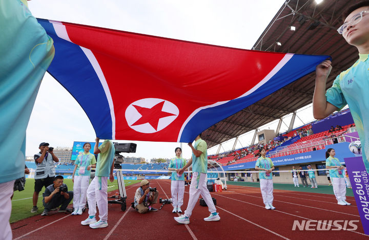 [진화(중국)=뉴시스] 고승민 기자 = 19일 중국 진화 저장대 동 스타디움에서 열린 2022 항저우 아시안게임 남자축구 조별리그 F조 1차전 북한 대 대만 경기, 북한 인공기가 경기장 안으로 들어오고 있다. 2023.09.19. kkssmm99@newsis.com