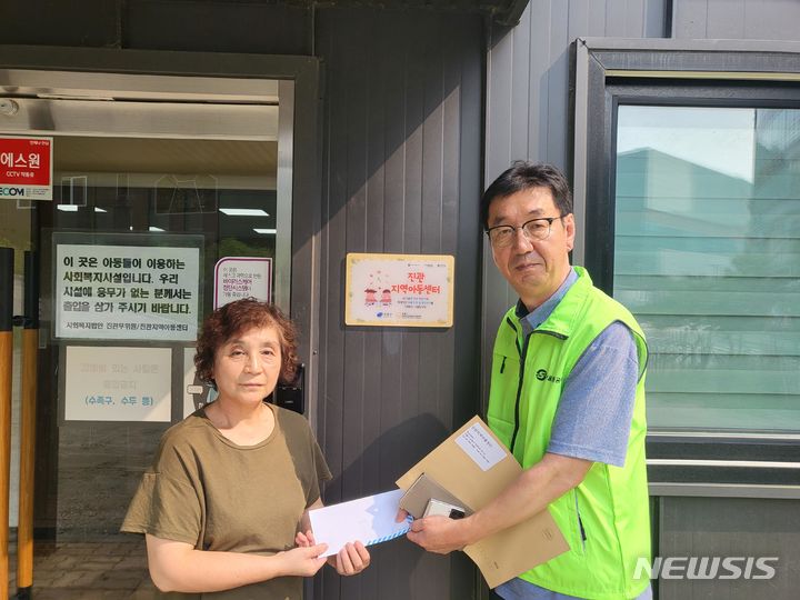 [서울=뉴시스]김창동 구파발역 역장(오른쪽)이 진관아동지역센터를 방문해 진관아동지역센터 관계자에게 가장 유실자가 남기고 간 50만원을 기부했다.