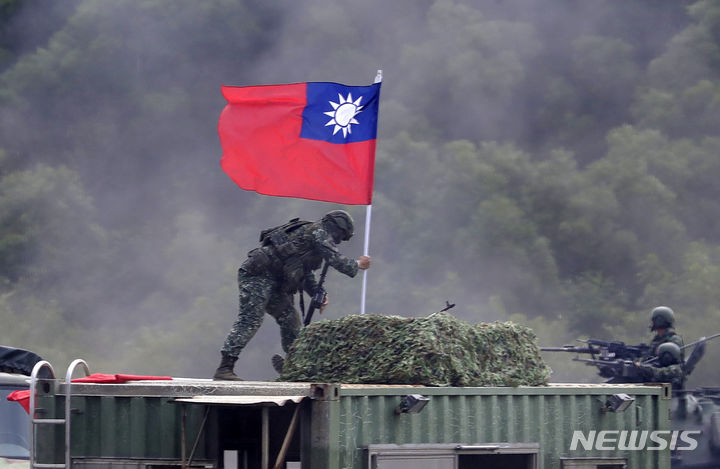 [신주=AP/뉴시스] 대만에서 중국에 항복한다고 맹세하는 '심리전' 영상을 촬영한 현역 군인을 포함해 전현직 군인 10명이 국가보안법 위반 혐의로 기소됐다. 사진은 지난 9월 21일 대만 신주현의 한 군사기지에서 훈련에 참여한 대만 군인이 진지에 대만 깃발을 꽂는 모습. 2023.11.28