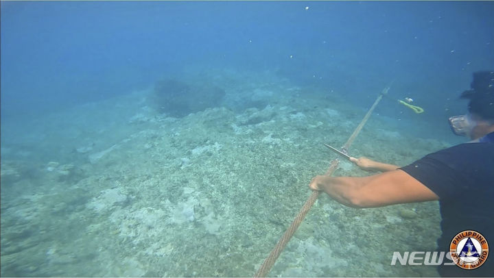 [마닐라=AP/뉴시스]필리핀 정부는 26일(현지시간) 필리핀 해상경비대 소속 잠수부가 중국이 설치한 해상 장벽의 밧줄을 잘라내는 장면이 담긴 동영상을 공개했다. 2023.9.27.