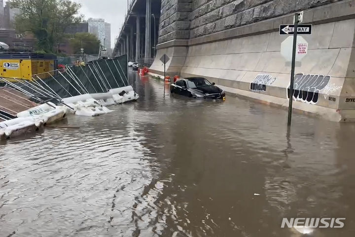 [뉴욕=AP/뉴시스]29일(현지시간) 뉴욕 윌리엄스버그 다리 인근에서 홍수로 인해 자동차 한 대가 좌초된 모습. 