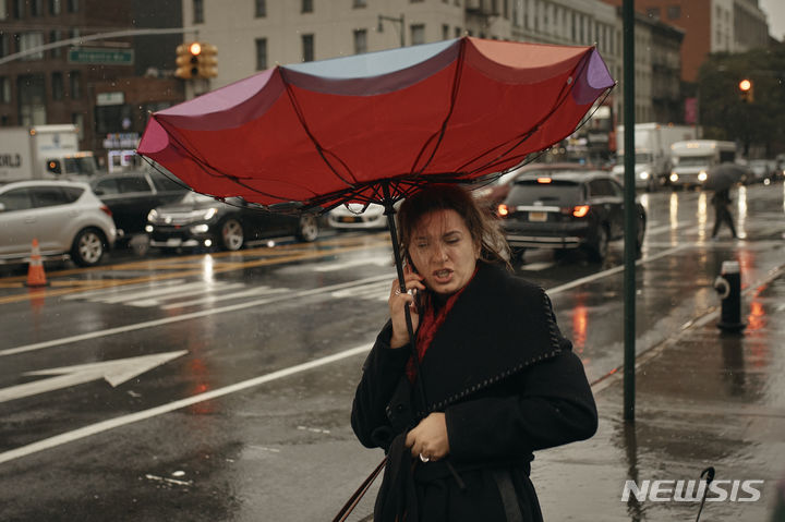 [뉴욕=AP/뉴시스] 29일(현지시각) 미국 뉴욕 브루클린 자치구에서 전화 통화를 하는 여성의 우산이 강풍에 뒤집히고 있다. 뉴욕 일대에 폭우가 쏟아져 일부 지하철과 통근 열차 운행이 중단돼 출근길 시민들이 대란을 겪었다. 2023.09.30.