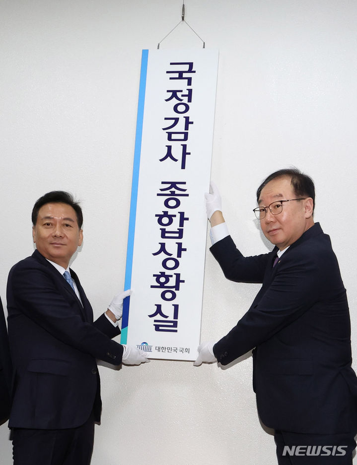 [서울=뉴시스] 추상철 기자 = 이광재(왼쪽) 국회사무총장과 권영진 입법차장이 4일 서울 여의도 국회 의사과 앞에서 열린 국정감사 종합상황실 현판식에서 현판을 걸고 있다. (공동취재사진) 2023.10.04. photo@newsis.com