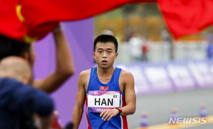 [항저우=뉴시스] 정병혁 기자 = 5일 중국 항저우 첸탕강 스마트 뉴월드 일대에서 열린 2022 항저우 아시안게임 육상 남자 마라톤에서 은메달을 차지한 북한 한일룡이 결승선을 통과한 뒤 자국 응원단을 찾고 있다