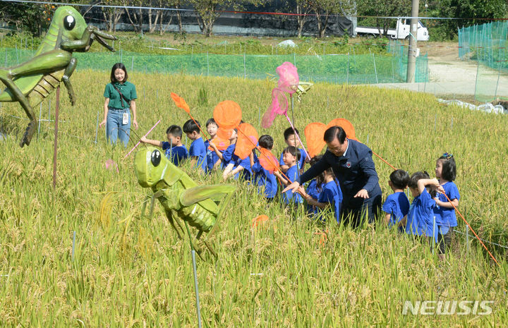 [완주=뉴시스] 김얼 기자 = 제11회 완주와일드&로컬푸드축제 개막을 하루 앞둔 5일 전북 완주군 고산자연휴양림 일원에서 사전 체험행사에 참가한 유희태 완주군수와 어린이들이 메뚜기 잡기를 하고 있다. 2023.10.05. pmkeul@newsis.com