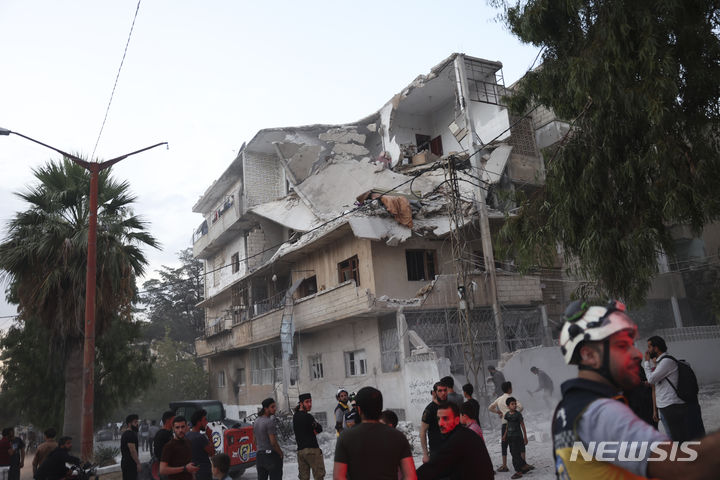 [AP/뉴시스] 시리아의 아레하 시에서 10월 5일 정부군 시설에 대한 공습으로 파괴된 건물들과 구조 작업에 나선 민방위구급대원들. 2023.11.27.
