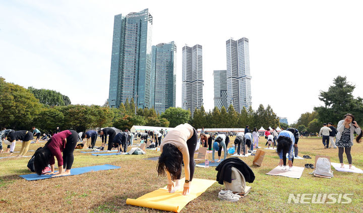 [서울=뉴시스] 최진석 기자 = 7일 서울 성동구 서울숲에서 열린 ‘2023 서울 웰니스 위크(Seoul Wellness Week)’에서 참가자들이 요가 플래시몹을 하고 있다. 2023.10.07. myjs@newsis.com