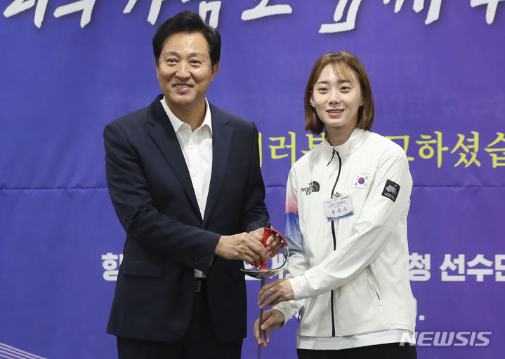 [서울=뉴시스] 김근수 기자 = 오세훈 서울시장이 10일 오전 서울 중구 서울시청 간담회장에서 열린 2022 항저우 아시안게임 참가 선수단 격려 간담회에서 항저우 아시안게임 여자 펜싱 사브르 금메달리스트 윤지수 선수에게 펜싱칼을 선물 받고 기념촬영을 하고 있다. 2023.10.10. ks@newsis.com