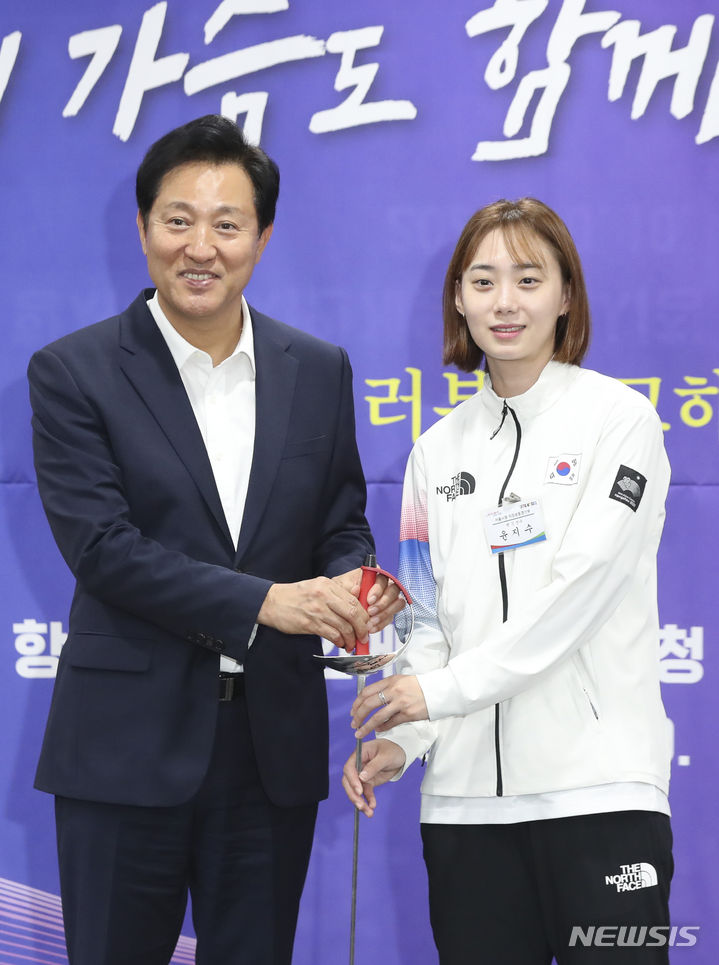 [서울=뉴시스] 김근수 기자 = 오세훈 서울시장이 10일 오전 서울 중구 서울시청 간담회장에서 열린 2022 항저우 아시안게임 참가 선수단 격려 간담회에서 항저우 아시안게임 여자 펜싱 사브르 금메달리스트 윤지수 선수에게 펜싱칼을 선물 받고 기념촬영을 하고 있다
