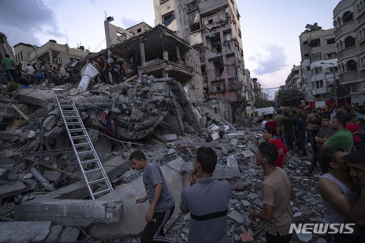 [AP/뉴시스]이스라엘 공군의 폭격으로 파괴된 가자지구 국경의 팔레스타인 거주지에서 10일 주민들이 매몰된 부상자들을 구조하고 있다. 2023.10.11. 