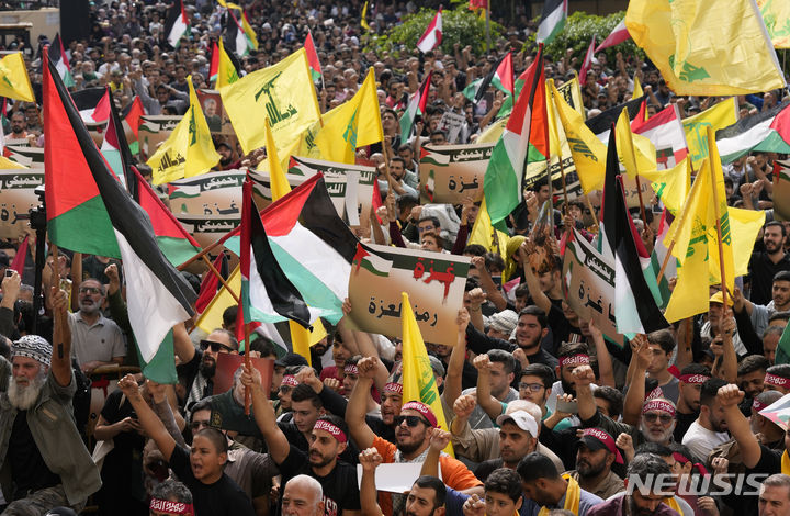[베이루트=AP/뉴시스]레바논의 헤즈볼라 지지 시위대가 수도 베이루트 남부에서 레바논국기, 팔레스타인 깃발, 헤즈볼라 깃발을 흔들며 이스라엘의 가자 공격에 항의시위를 하고 있다. 2023.12.13.