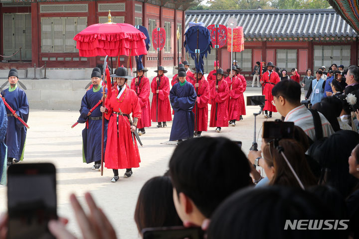 [서울=뉴시스] 배훈식 기자 = 13일 오전 서울 종로구 경복궁을 찾은 관광객들이 궁궐의 일상 모습을 체험할 수 있는 '왕가의 산책' 재연 행사를 관람하고 있다. 2023.10.13. dahora83@newsis.com