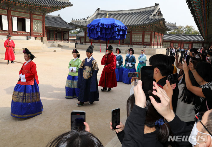 [서울=뉴시스] 배훈식 기자 = 13일 오전 서울 종로구 경복궁을 찾은 관광객들이 궁궐의 일상 모습을 체험할 수 있는 '왕가의 산책' 재연 행사를 관람하고 있다. 2023.10.13. dahora83@newsis.com