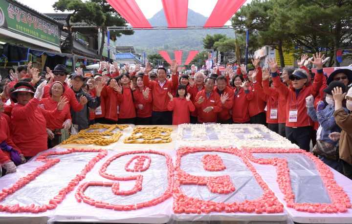 [순창=뉴시스] 김종효 기자 = 14일 ‘제18회 순창장류축제’ 2일차, 새롭게 선보인 축제 주요 프로그램 ‘300m 가래떡 꼬기’가 열띤 성원 속에 펼쳐졌다. 행사 후 나눔떡으로 잘려 모양을 낸 가래떡판 주위로 참여자들이 기념사진을 찍고 있다. (사진 = 순창군 제공) 2023.10.14. photo@newsis.com *재판매 및 DB 금지