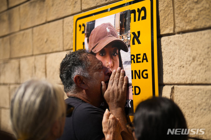 [텔아비브=AP/뉴시스] 14일(현지시각) 이스라엘 텔아비브에서 하마스에 납치된 이스라엘 사람들의 석방을 요구하는 시위에 참여한 한 남성이 납치된 딸의 사진에 얼굴을 대고 흐느끼고 있다. 2023.10.15.