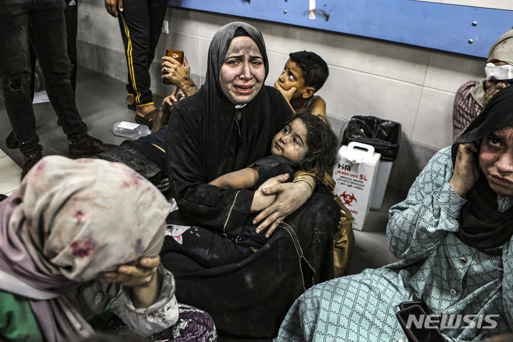 [가자시티=AP/뉴시스]팔레스타인 가자지구 내 알 아흘리 병원이 로켓 공격을 받아 수백명의 사상자가 발생한 17일(현지시간) 부상을 입은 한 팔레스타인들이 병원 복도에 앉아 통곡하고 있다. 2023.10.18