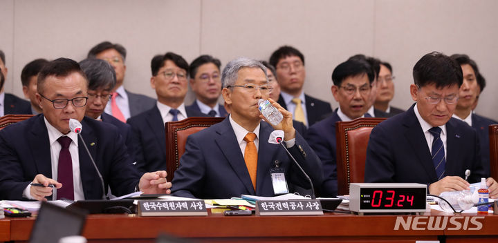 [서울=뉴시스] 이영환 기자 = 김동철 한국전력공사 사장이 19일 오전 서울 여의도 국회에서 열린 산업통상자원중소벤처기업위원회의 한국전력공사 등에 대한 국정감사에서 물을 마시고 있다. 왼쪽부터 황주호 한국수력원자력 사장, 김 사장, 정동희 한국전력거래소 이사장. 2023.10.19. 20hwan@newsis.com