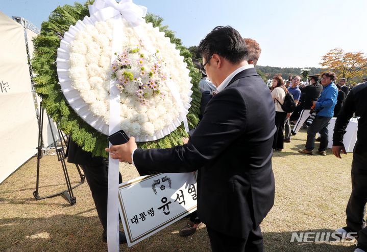 25일 국립대전현충원에서 열린 홍범도장군 순국 80주기 추모 및 청산리전투 전승 103주년 기념식에서 홍범도 장군 묘역 앞에 놓인 윤석열 대통령의 근조화환을 황인호 전 대전 동구청장이 행사장 옆으로 돌려 밀어냈다. (공동취재사진) 2023.10.25. photo@newsis.com