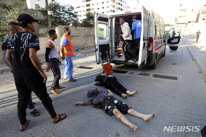 [가자지구=AP/뉴시스] 25일(현지시각) 가자지구 가자시티에서 팔레스타인 주민들이 이스라엘의 공습 이후 거리에서 발견된 부상 여성들을 구급차로 옮기고 있다. 2023.10.26.