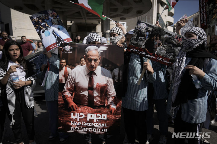 [나블루스=AP/뉴시스] 26일(현지시각) 요르단강 서안 나블루스에서 팔레스타인 주민들이 '전쟁범죄'라고 쓰인 베냐민 네타냐후 이스라엘 총리의 사진을 들고 이스라엘의 가자 지구 폭격에 반대하는 시위를 벌이고 있다. 2023.10.27.