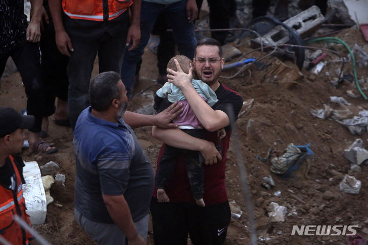 [ 누세이라트( 가자지구)=AP/뉴시스] 팔레스타인 남성 한 명이 10월 31일 이스라엘 폭격으로 무너진 가자지구 누세이라트 난민촌의 건물 폐허에서 파낸 아들의 시신을 안고 울부짖고 있다. 2023.11.01.  