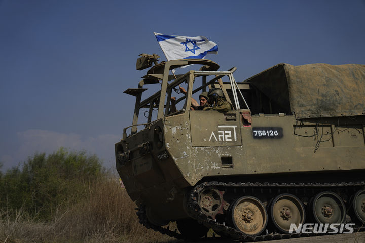 [가자지구=AP/뉴시스] 1일(현지시각) 장갑차에 탑승한 이스라엘 군인들이 가자지구로 향하면서 국기를 흔들고 있다. 이스라엘 지상군이 최근 며칠 동안 가자지구에서 하마스 시설 300여 곳을 타격하는 등 강도 높은 작전을 수행하고 있다. 2023.11.02.
