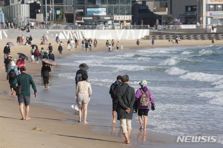 [부산=뉴시스] 하경민 기자 = 늦가을 이례적인 고온 현상이 나타난 2일 부산 해운대구 해운대해수욕장을 찾은 시민과 관광객들이 시원한 바닷물에 발을 담그고 있다. 2023.11.02. yulnetphoto@newsis.com