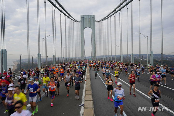 [뉴욕=AP/뉴시스] 5일(현지시간) 미국 뉴욕에서 열린 뉴욕 마라톤 대회에 참가한 러너들이 역주하고 있다. 2023.11.06.