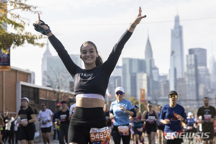 [뉴욕=AP/뉴시스] 5일(현지시간) 미국 뉴욕에서 열린 뉴욕 마라톤 대회에 참가한 러너가 포즈를 취하며 달리고 있다. 2023.11.06.