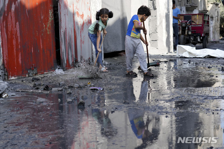 [가자지구=AP/뉴시스] 5일(현지시각) 가자지구 알마가지 난민촌에서 팔레스타인 어린이들이 이스라엘의 폭격으로 어수선한 집 밖 도로를 치우고 있다. 2023.11.06.