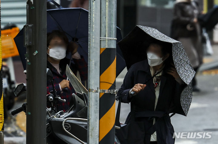 [서울=뉴시스] 정병혁 기자 = 서울지역에 강풍주의보가 내려진 6일 서울 마포구 만리재로에서 시민들이 우산을 부여잡은 채 이동하고 있다. 2023.11.06. jhope@newsis.com