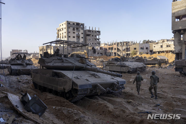 [가자지구=AP/뉴시스] 8일(현지시각) 가자 지구의 파괴된 건물 주변에서 지상 작전 중인 이스라엘군 전차들이 대기하고 있다. 2023.11.09.