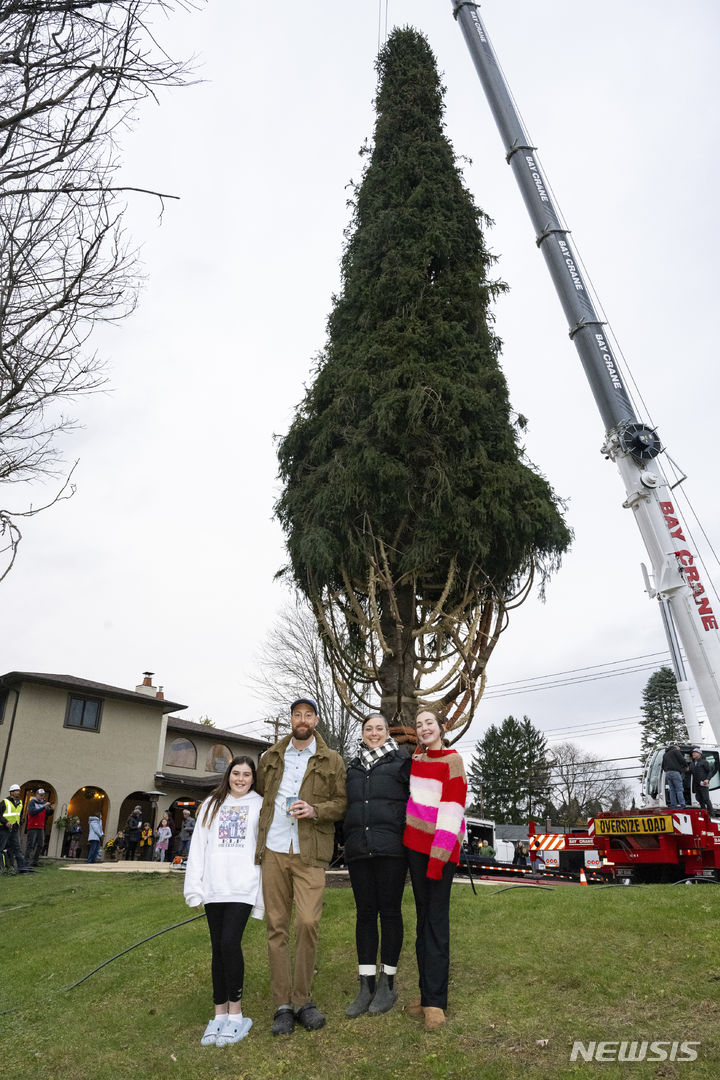 [베스털=AP/뉴시스] 9일(현지시각) 미국 뉴욕의 베스털에서 올해 록펠러 센터에 설치될 크리스마스트리를 기증한 가족이 나무 앞에서 기념 촬영을 하고 있다. 이 나무는 높이 약 25m, 무게 12톤의 노르웨이 가문비나무로 오는 11일 록펠러 센터 앞에 설치돼 29일부터 점등된다. 2023.11.10.