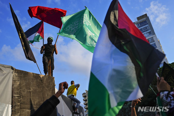[베이루트=AP/뉴시스] 레바논 베이루트에 있는 영국 대사관 부근에서 11월 14일 친팔레스타인 시위대가 반영국 구호를 외치며 팔레스타인과 하마스 깃발을 흔들고 있다. 2023.12.06.