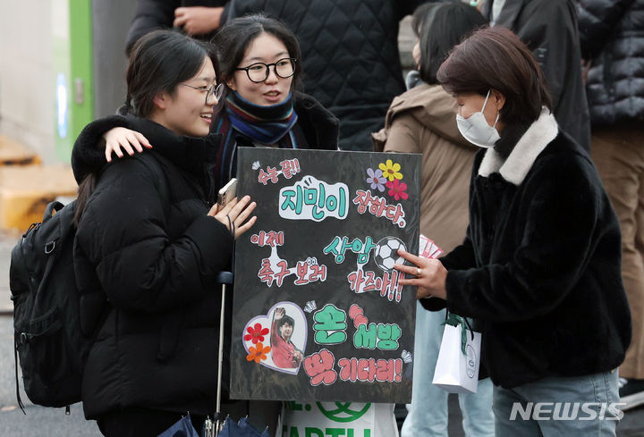 [서울=뉴시스] 조성우 기자 = 2024학년도 대학수학능력시험일인 16일 서울 중구 이화여자외국어고등학교에서 수능 시험을 마친 수험생(가운데)이 부모님이 건넨 응원 팻말을 들고 있다. 2023.11.16. xconfind@newsis.com