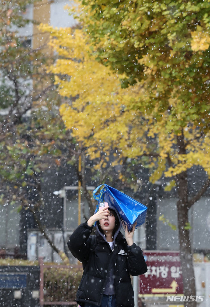 [인천=뉴시스] 전진환 기자 = 17일 오전 서울 남동구 인천시청 앞 광장 일대에 첫 눈이 내리는 가운데 한 시민이 핸드폰으로 사진을 찍고 있다. 2023.11.17. amin2@newsis.com