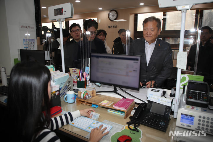 [서울=뉴시스] 권창회 기자 = 이상민 행정안전부 장관이 19일 서울 종로구 청운효자동 주민센터를 방문해 정부 행정전산망인 '새올'과 사회보장통합정보시스템 '행복이음'의 정상 작동 여부를 확인한 뒤 주민등록등본 서류를 발급받고 있다. (공동취재) 2023.11.19. photo@newsis.com