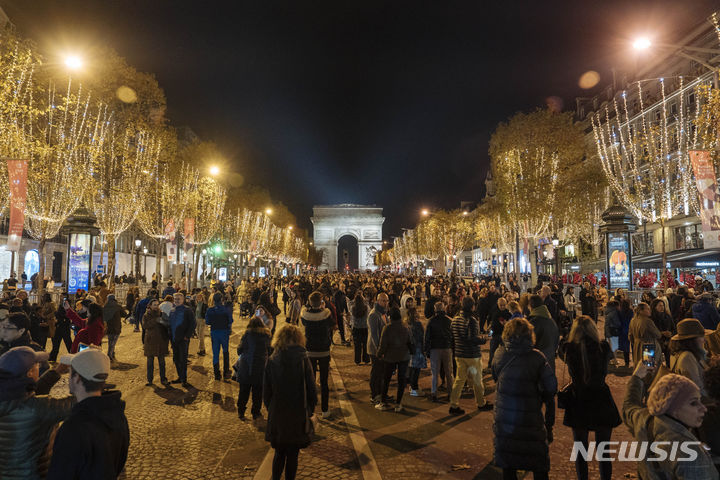 [파리=AP/뉴시스] 19일(현지시각) 프랑스 파리에서 크리스마스 시즌 샹젤리제 거리 점등식이 열려 시민들이 거리에 모여 있다. 2023.11.20.