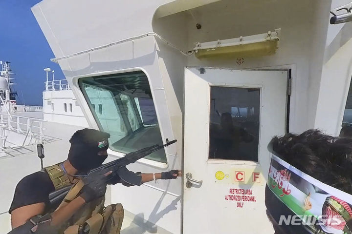[사나=AP/뉴시스] ] 예멘 후티 반군은 이스라엘과 협력하는 모든 해운사는 홍해에서 공격의 목표물이 될 것이라고 경고했다고 AFP통신이 9일(현지시간) 보도했다. 사진은 후티 반군 측이 공개한 영상 사진에 지난달 19일 자동소총으로 무장한 후티군 병사가 화물선 갤럭시 리더호에 승선해 조타실로 접근하는 모습. 2023.12.09. 