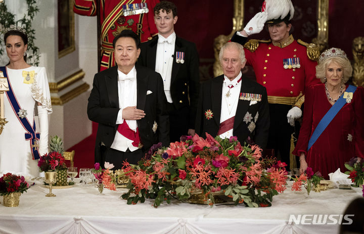 [런던=AP/뉴시스] 윤석열(왼쪽) 대통령이 21일(현지시각) 영국 런던의 버킹엄궁에서 열린 국빈 만찬에 참석해 찰스 3세 국왕 부부와 함께 국민의례를 하고 있다. 2023.11.22.