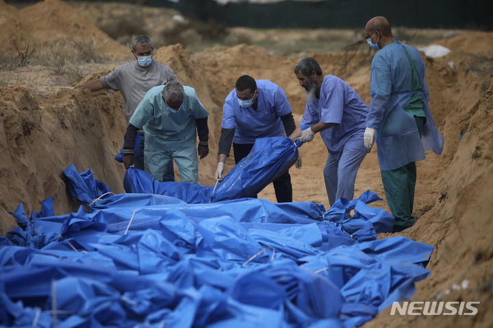 [칸유니스=AP/뉴시스] 22일(현지시각) 가자지구 칸 유니스에서 팔레스타인인들이 이스라엘의 폭격으로 숨진 사람들의 시신을 집단 매장하고 있다. 이 시신들은 집단 매장을 위해 알 시파 병원에서 이송된 것으로 알려졌다. 2023.11.23.