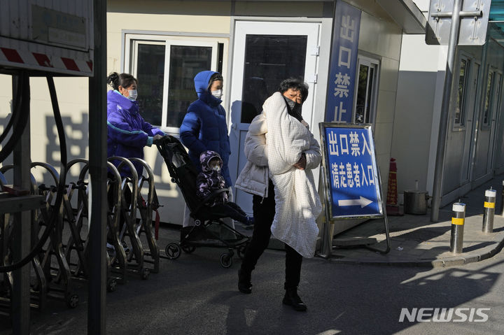 [베이징=AP/뉴시스]최근 중국에서 주로 어린이들 사이에 마이코플라스마 폐렴이 유행하는 것과 관련해 중국 당국과 전문가가 마이코플라스마뿐 아니라 다양한 호흡기질환이 발병하는 데 따른 것이라는 분석을 내놨다. 사진은 지난 24일 한 여성이 베이징의 한 어린이병원을 떠나면서 아이를 안고 있는 모습. 2023.11.27