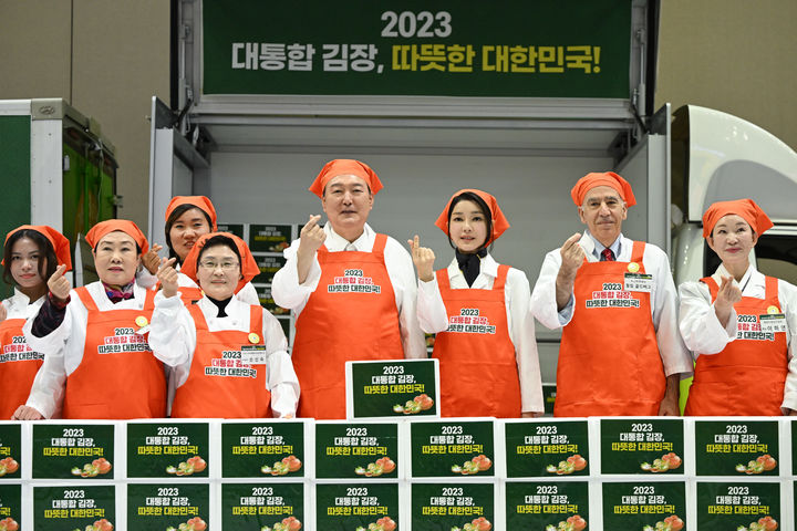 [고양=뉴시스] 윤석열 대통령과 부인 김건희 여사가 27일 경기 고양시 킨텍스에서 열린 나눔과 봉사의 국민 대통합 김장 행사에서 소외계층에 전달할 김장 김치 박스를 놓고 기념촬영을 하고 있다. (사진=대통령실 제공) 2023.11.27 photo@newsis.com *재판매 및 DB 금지