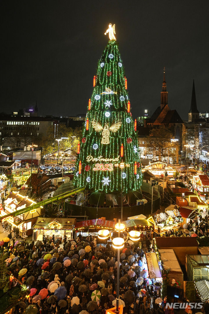 [도르트문트=AP/뉴시스] 프란치스코 교황이 성탄절에는 우크라이나 전장에서 포성이 멈추기를 바란다는 뜻을 전했다. 사진은 지난달 27일(현지시각) 독일 도르트문트의 비 내리는 크리스마스마켓에서 시민이 45m 높이의 전통 크리스마스트리를 구경하는 모습. 2023.12.12.