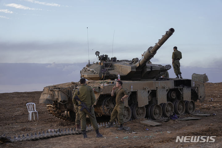 [가자지구=AP/뉴시스] 이스라엘과 하마스의 임시 휴전 닷새째인 28일(현지시각) 이스라엘 남부 가자지구 인근 주둔지에서 이스라엘 군인들이 전차를 정비하고 있다. 2023.11.29.