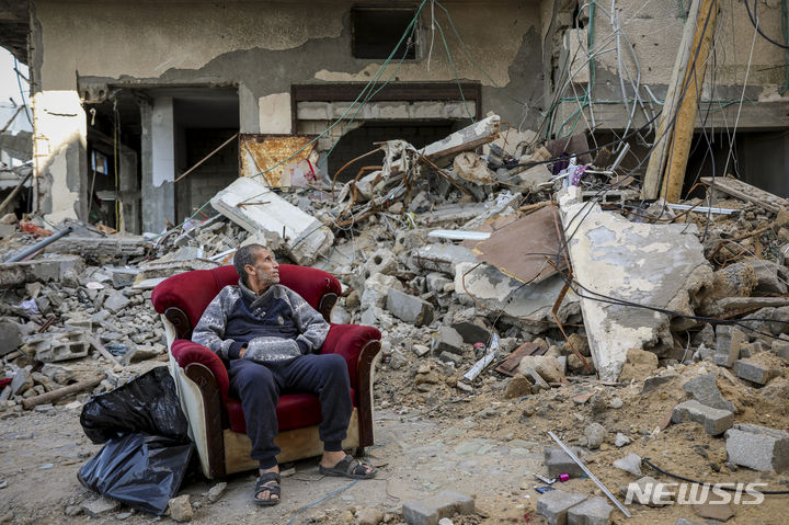[가자지구=AP/뉴시스] 이스라엘과 하마스의 임시 휴전 마지막 날인 29일(현지시각) 가자지구 가자시티에서 한 팔레스타인 주민이 이스라엘의 공격으로 폐허가 된 건물 앞 의자에 앉아 있다. 2023.11.30.