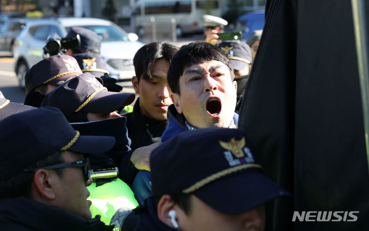 [서울=뉴시스] 김명년 기자 = 30일 오후 서울 용산구 대통령실 앞에서 열린 개식용 금지법안 추진 반대 집회에서 대한육견협회 관계자가 경찰에 끌려나가고 있다. 이들은 식용견을 싣고 온 자신들의 트럭을 경찰이 견인하려 하자 이를 막으려 경찰과 충돌을 했다. 2023.11.30. kmn@newsis.com