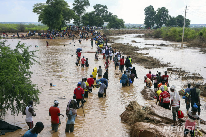 [모로로=AP/뉴시스] 지난달 30일(현지시각) 케냐 북동부 타나강과 가리사 카운티의 경계인 모로로 주민들이 홍수로 도로 일부가 파손되자 도보로 침수 지역을 건너고 있다. 2023.12.05.