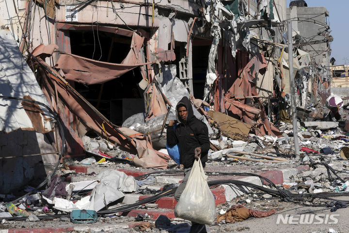 [가자시티=AP/뉴시스] 한 팔레스타인 주민이 지난 해12월 30일 가자지구 가자시티 외곽 알자흐라에서 이스라엘의 폭격으로 파괴된 집에 돌아와 쓸만한 물건을 찾아 챙기고 있다. 가자시티는 2월 25일까지도 폭격으로 사망자가 수십명씩 발생하고 있다. 2024.02.26. 